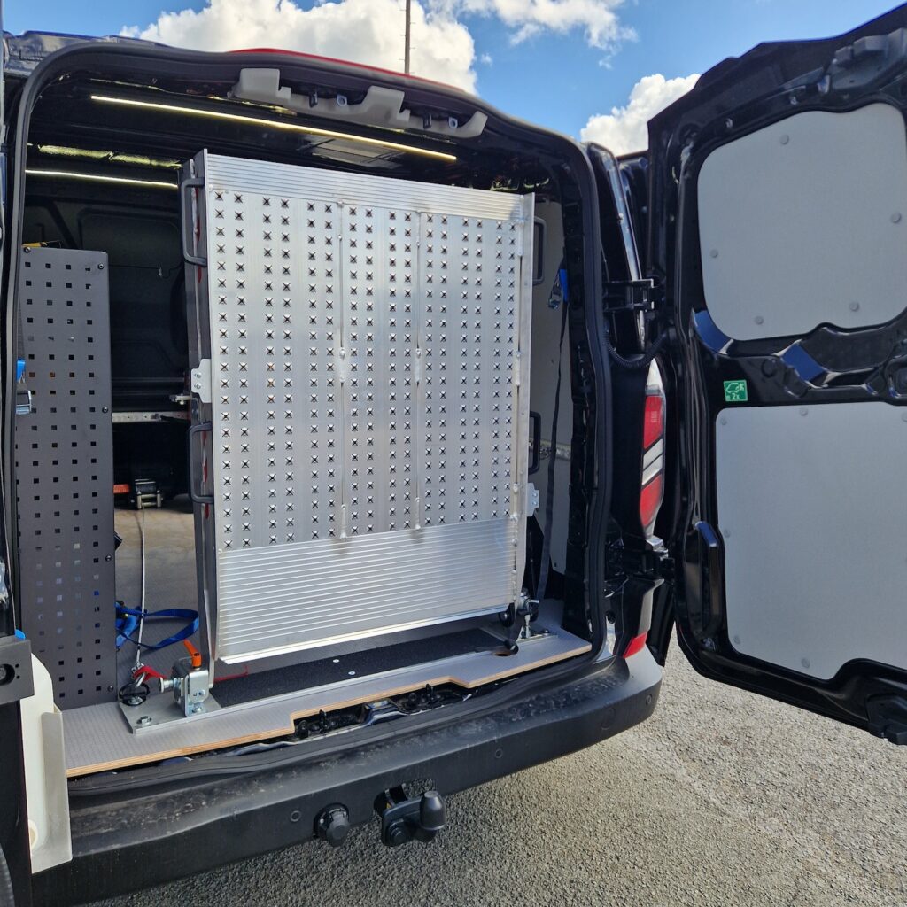 Rampe repliable verrouillée en position arrière dans le fourgon.Rampe repliable verrouillée en position arrière dans le fourgon.