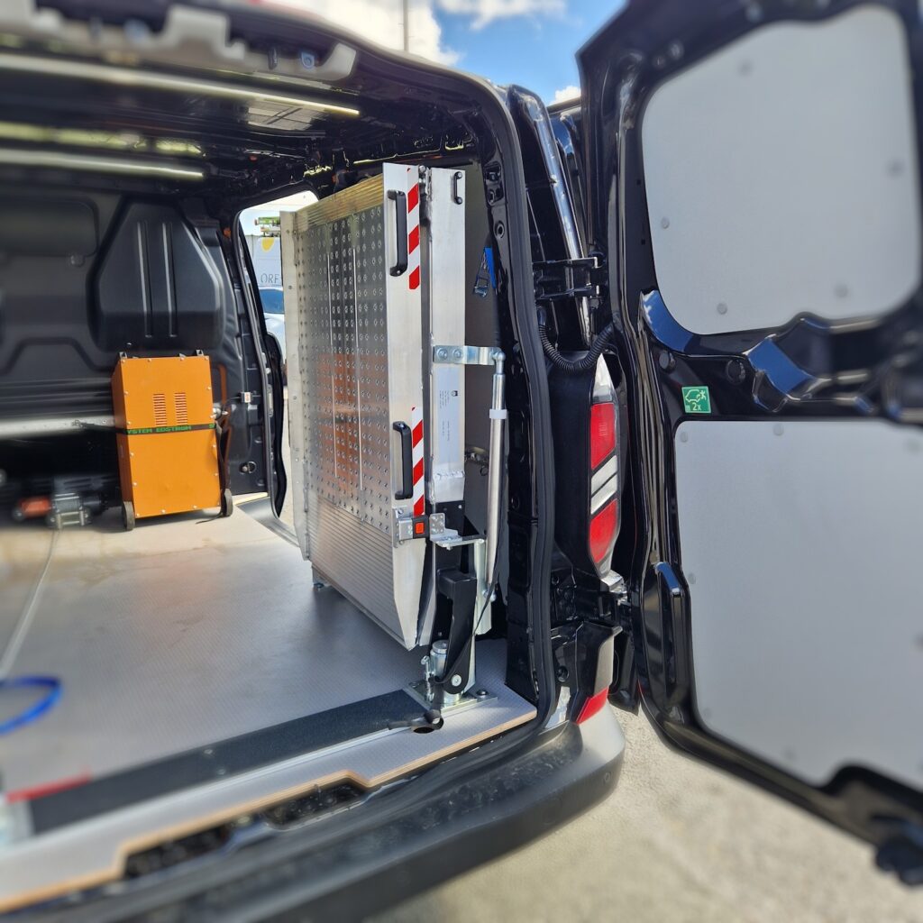 Rampe repliable pivotée et verrouillée contre le flanc pour libérer l’accès.