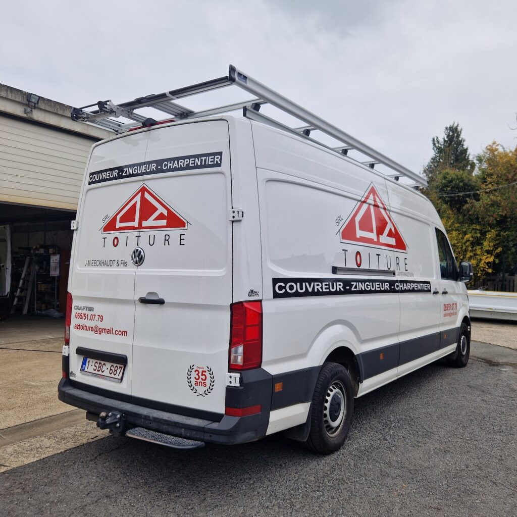 Vue latérale d'un Volkswagen Crafter L4H3 blanc avec marquage professionnel AZ Toiture et galerie de toit aluminium avec échelle intégrée