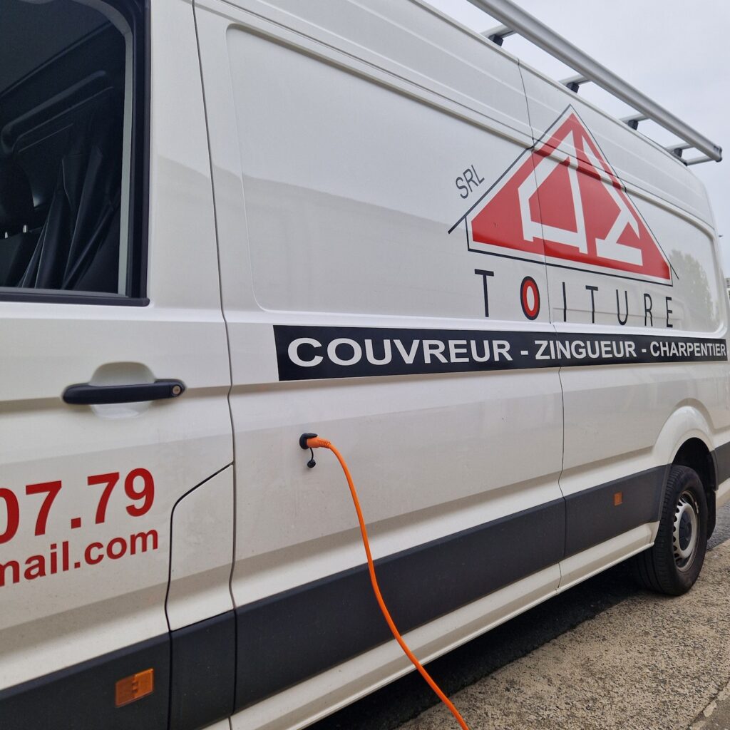 Gros plan sur le marquage AZ Toiture et les équipements du Volkswagen Crafter avec prise électrique orange et galerie aluminiumGros plan sur le marquage AZ Toiture et les équipements du Volkswagen Crafter avec prise électrique orange et galerie aluminium