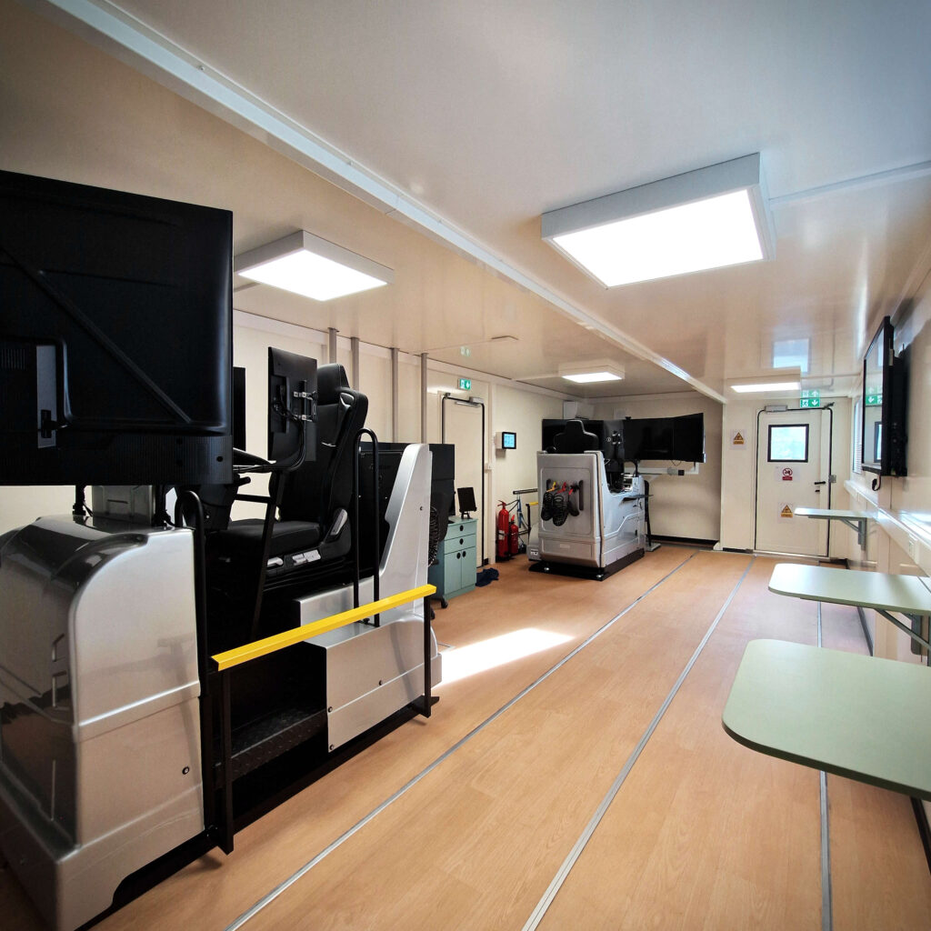 Intérieur du camion Le Forem : simulateurs de conduite poids lourds, écrans et espace de formation