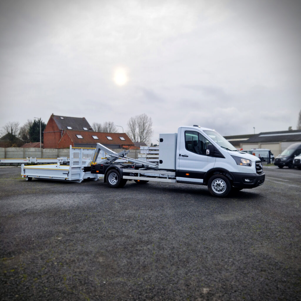 Ford Transit 5 tonnes avec plateau déposé au sol derrière le véhicule